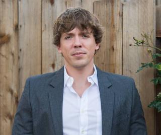 Scott Clark standing in front of fence