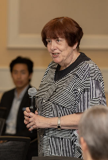 Judy Faucett speaking to audience from table