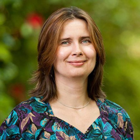 Oksana Ostroverkhova smiling on campus in spring