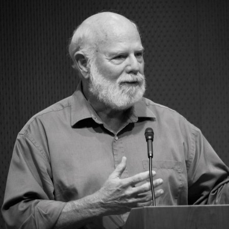 Image of Stevan J. Arnold: A male professor in short sleeve button-up shirt speaking at a podium.