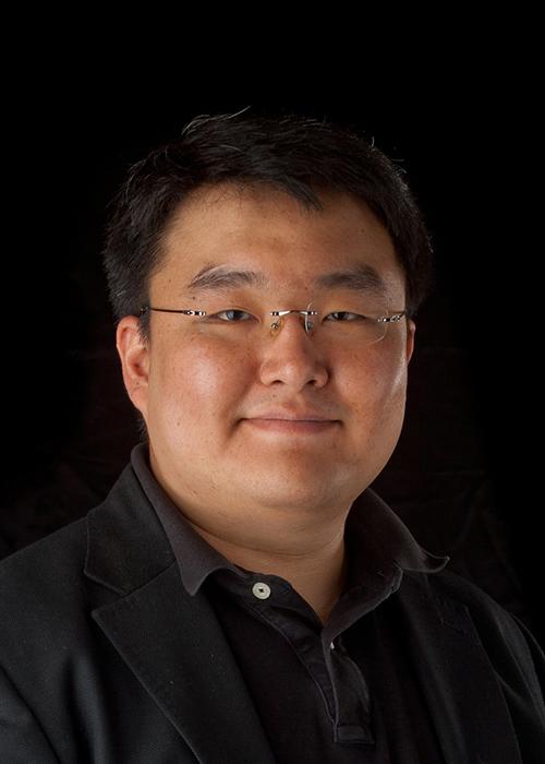 Paul Cheong in front of black backdrop