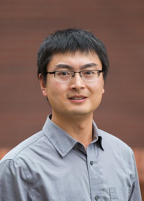 Ren Guo in front of brick wall