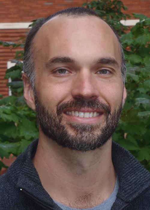 Ryan Mueller in front of shrubbery