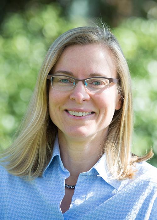 Mary Beisiegel in front of shrubbery