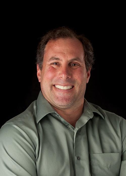 Richard Nafshun in front of black backdrop