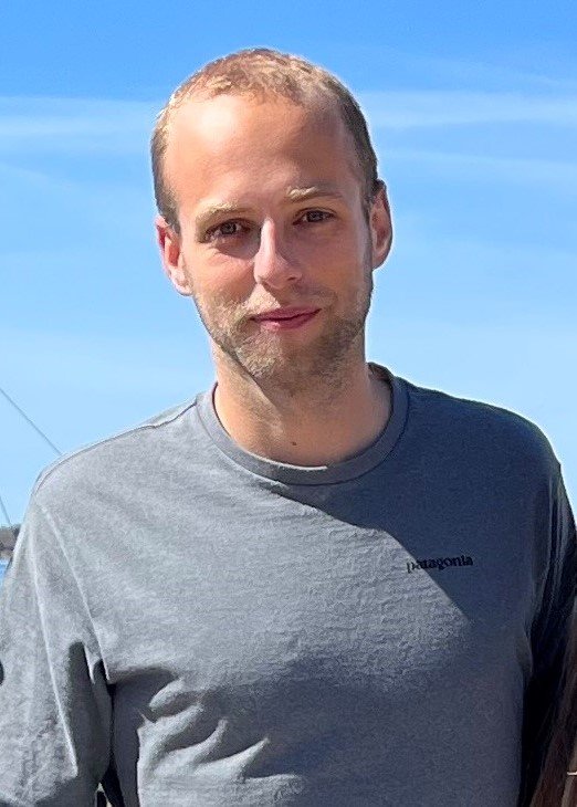 Fabian Wittmers standing outside with a blue sky behind him.