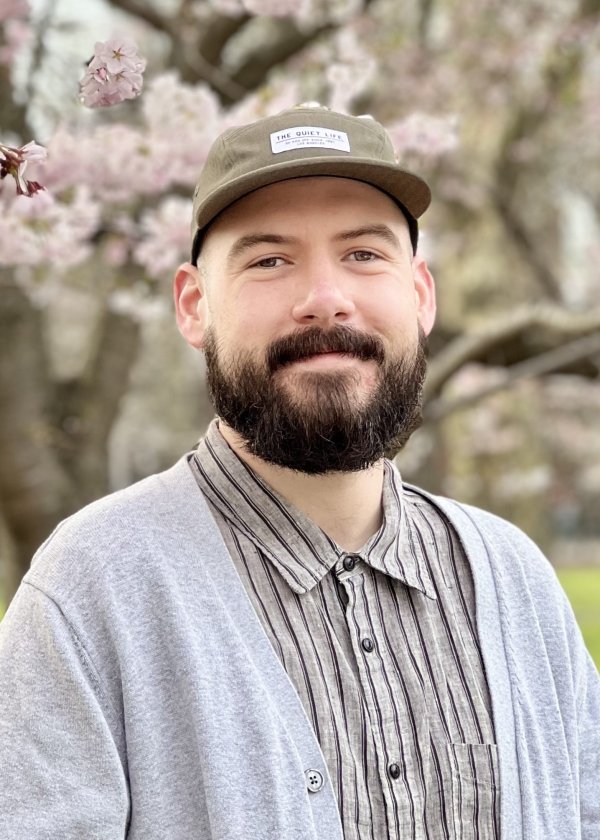 Nick Pokorzynski standing in front of a flowering tree.