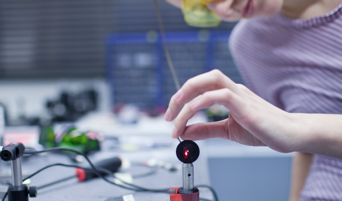 Student repairing laser equipment in lab