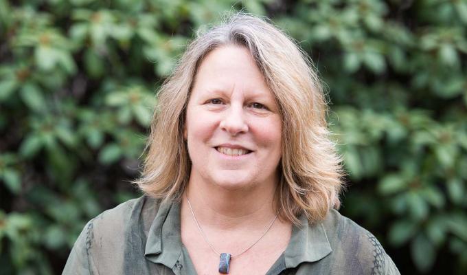 Jerri Bartholomew in front of shrubbery