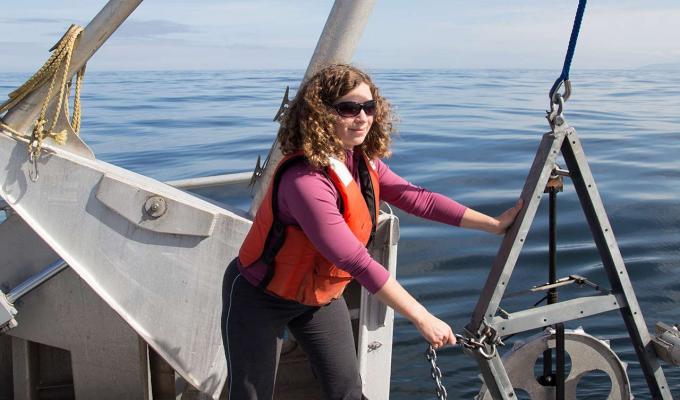 Sarah Henkel on a boat working with marine research machinery