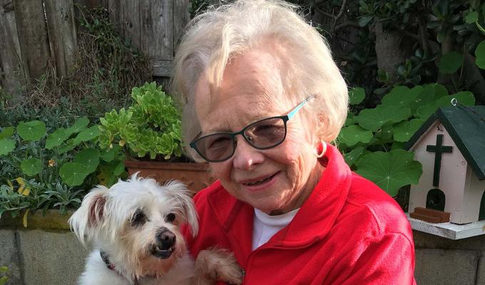 Karen Nickel holding dog in backyard bench