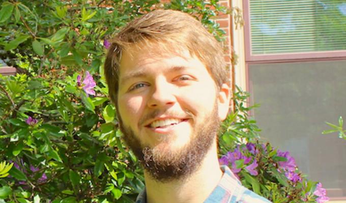 Justin Frost standing in front of shrubbery