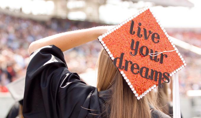 College graduate in decorated cap during graduation ceremony