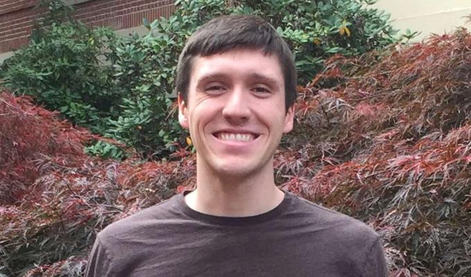 Nate Coddington in front of bush on OSU canvas