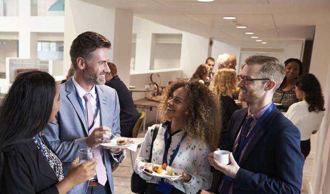 group of people talking to each other at a social event