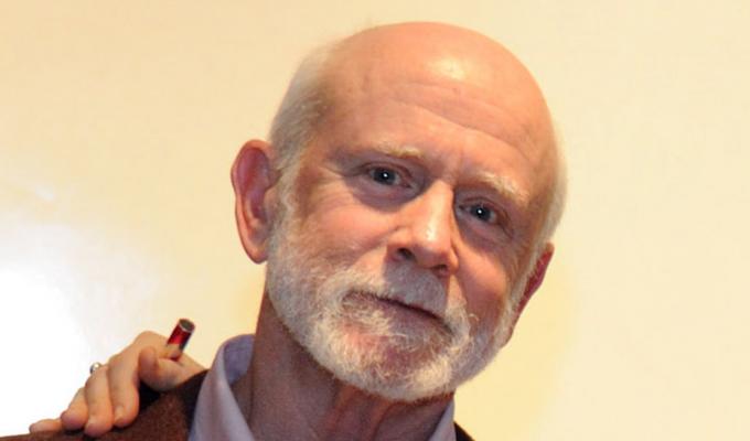 Robert Smythe in front of beige backdrop