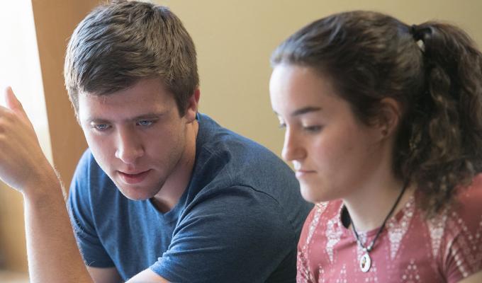 two students studying together in classroom