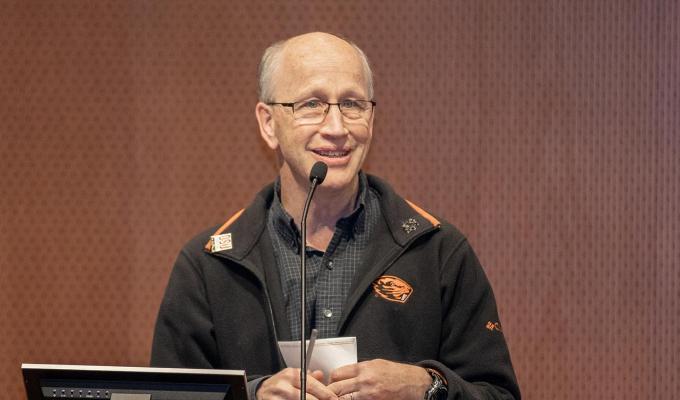 Andy Karplus talking behind podium