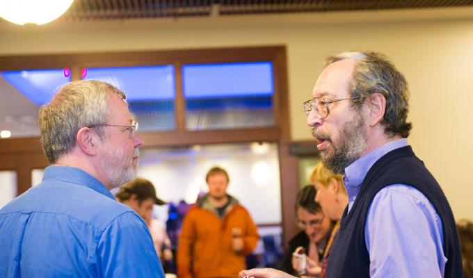 Tevian Dray talking with colleague in lobby
