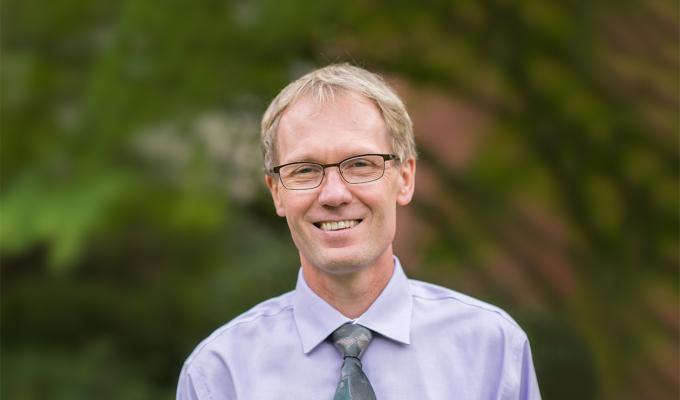 Roy Haggerty in front of shrubbery