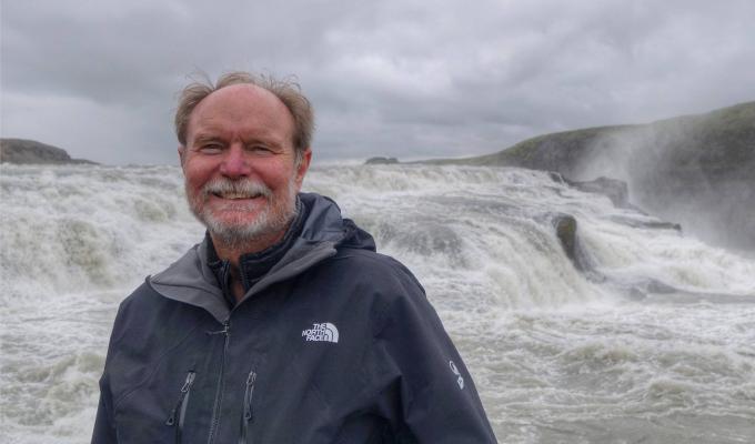 Joel Peterson standing in front of waterfall