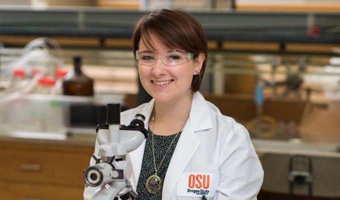 Grace Deitzler working with microscope in lab
