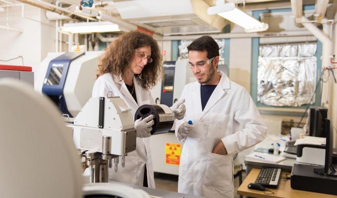 Ian Colliard working in a lab with Professor May Nyman