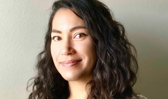 Katherine McLaughlin standing in front of a beige wall.
