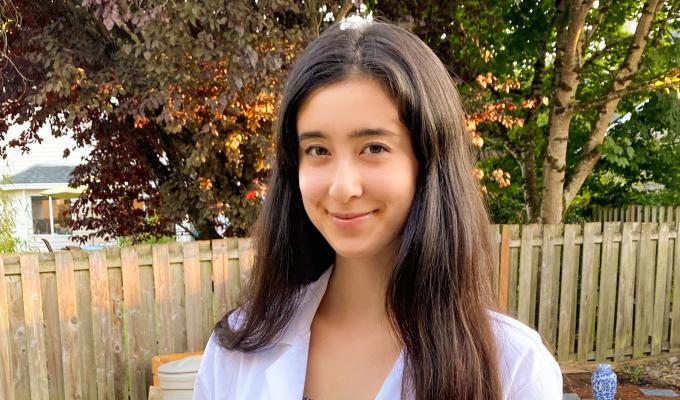 Gretchen Fujimura standing outside in a white lab coat. 