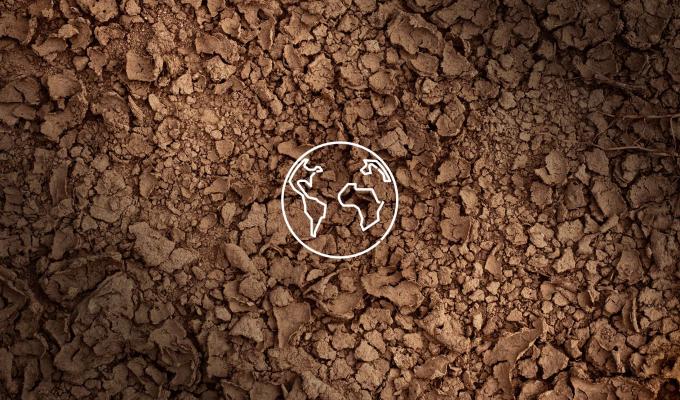 A background of brown soil with a white outline of earth. 