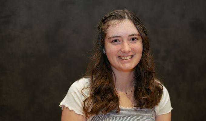 Madison Collins stands in front of a grey background.