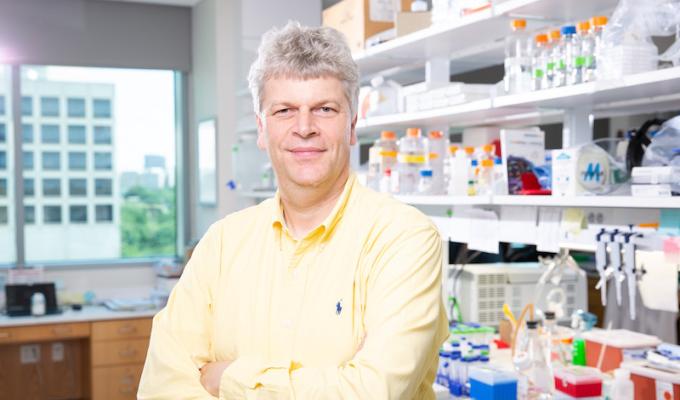 Danuser smiles in a headshot in a lab. 