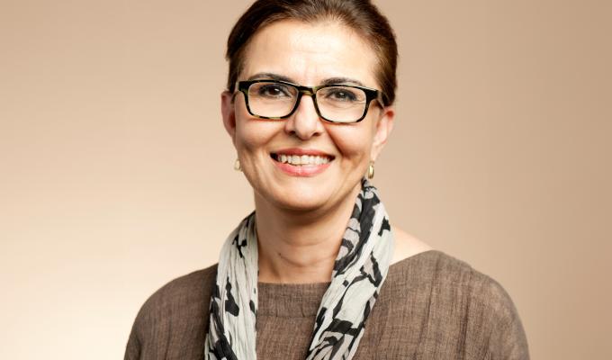 Headshot of a woman in a brown sweater.