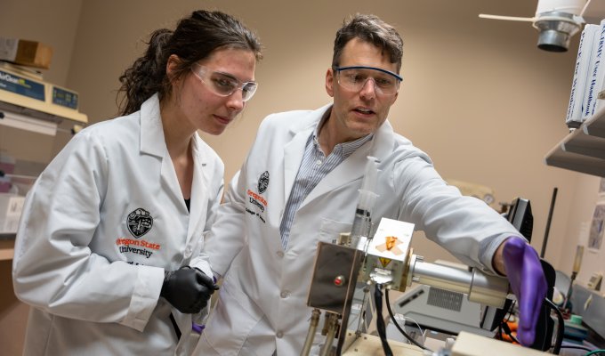 Two scientists use equipment in the GCE4All lab.