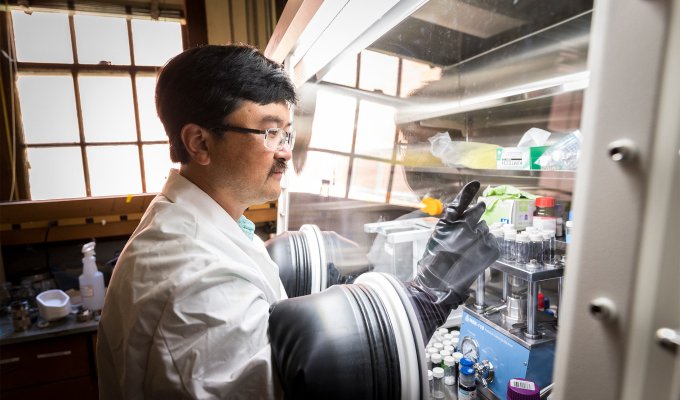 David Ji works in a chemistry lab wearing gloves in a tank.