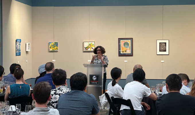 An audience listening intently to a speaker at the podium.