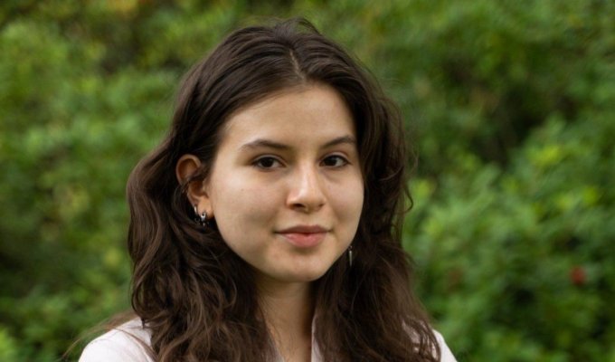 A woman in a pink shirt poses for a headshot.