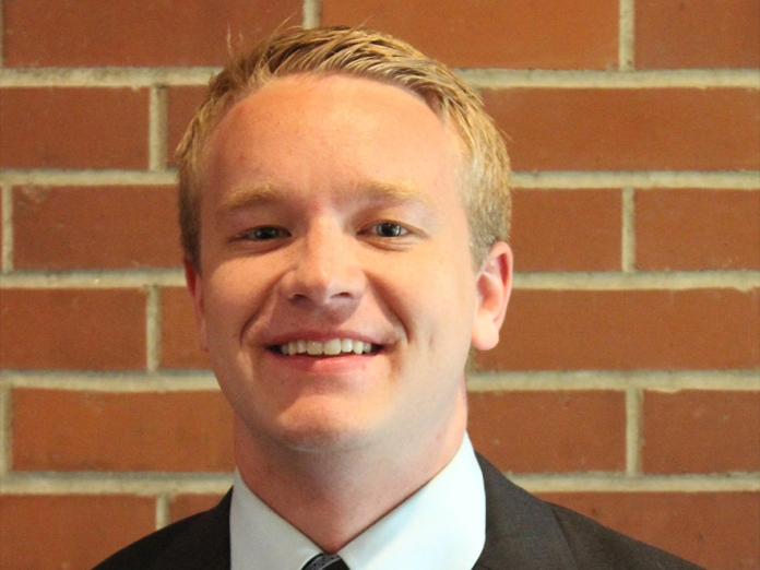 Braden Vogt, a man with short blonde hair in front of a brick background.