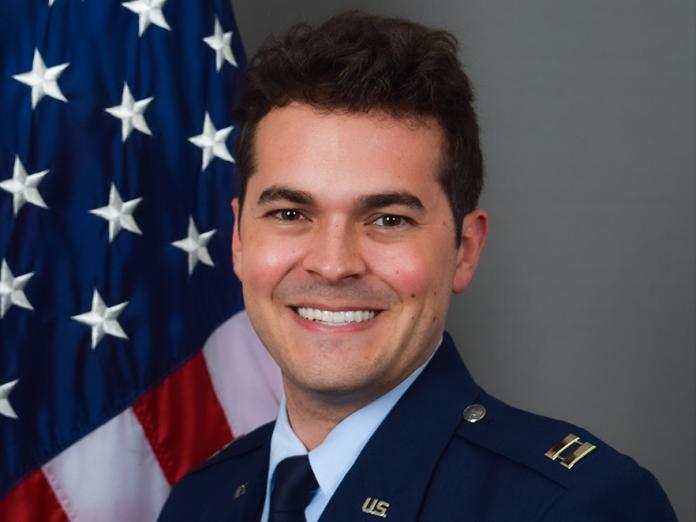 David Shumway, a man in military attire in front of the U.S. flag