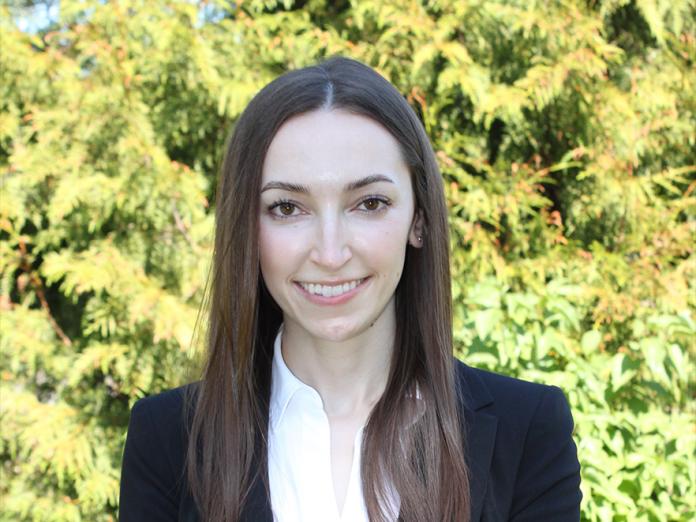 Kristin Potter, a woman with long brown hair, standing outside.