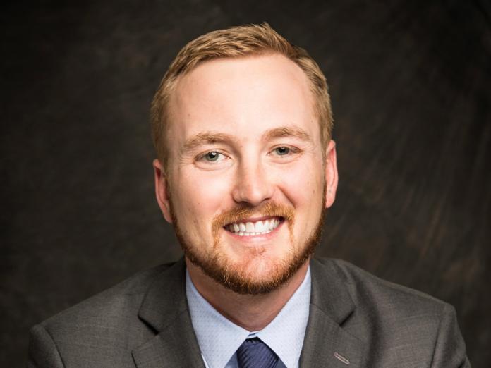Kevin Corey, a man with short blonde hair in a suit, smiling