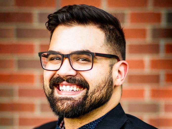 Omar Rachdi, a man smiling and wearing glasses.