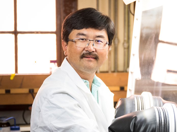 Headshot of David Ji working with a glovebox in the lab