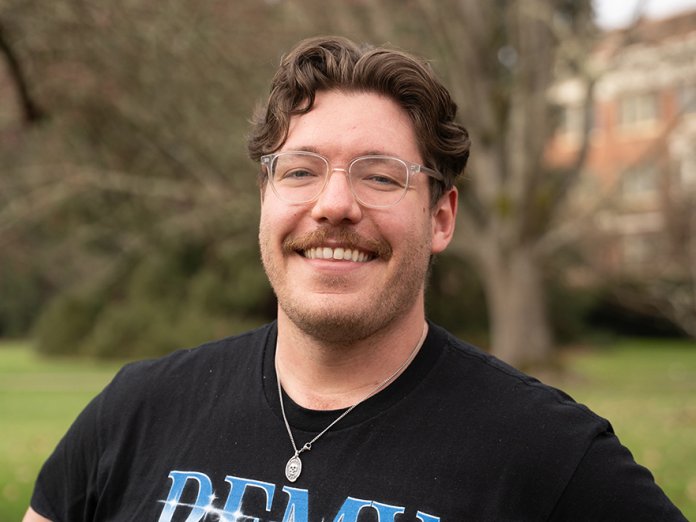 Smiling headshot of Eric Cole in a REMY band shirt
