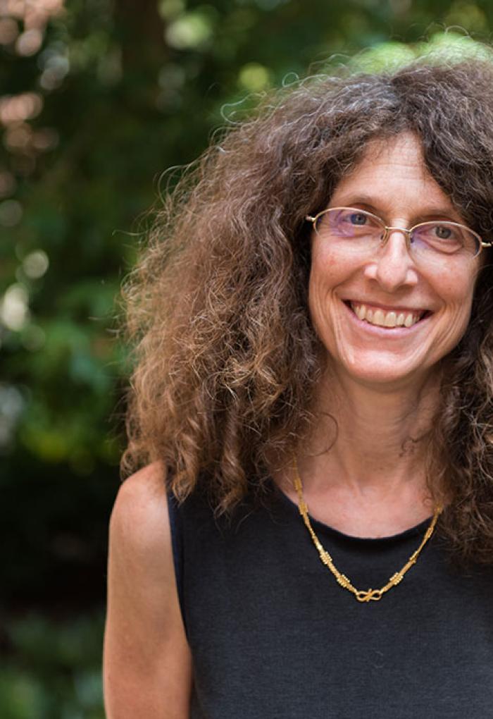 May Nyman standing in front of shrubbery