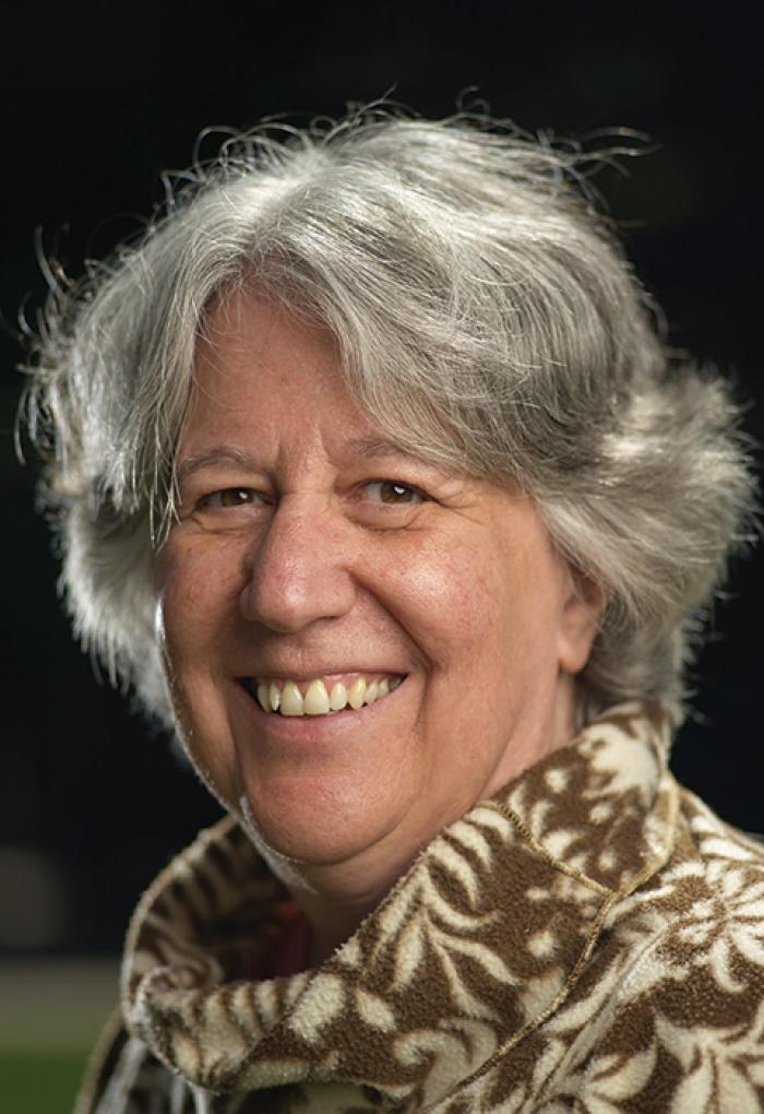 Corinne Manogue in front of black backdrop