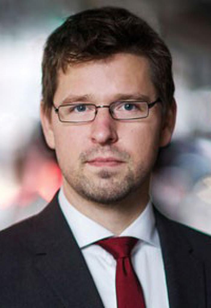 Simon Johnson in front of blurry backdrop