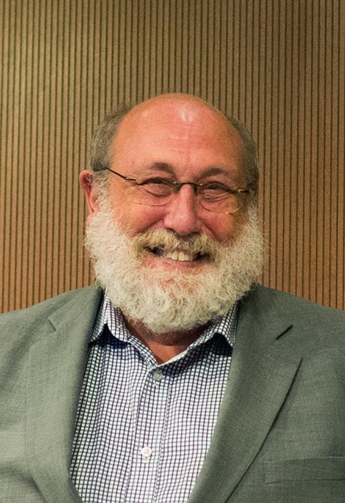 Tom Dick in front of wooden backdrop