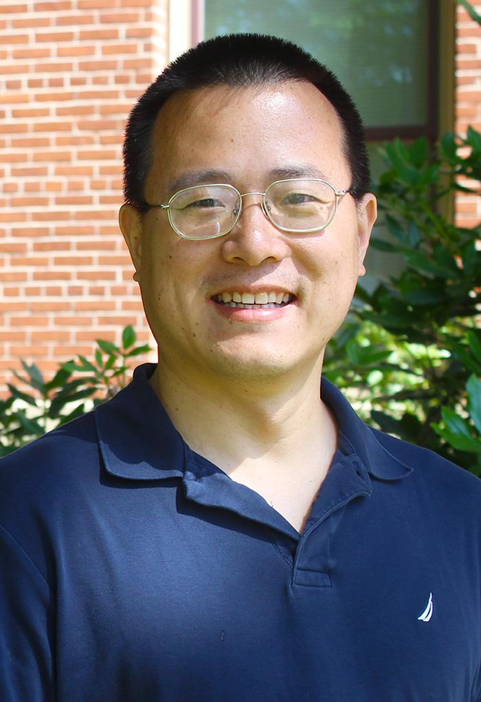 Yanming Di, a man with glasses standing outside.