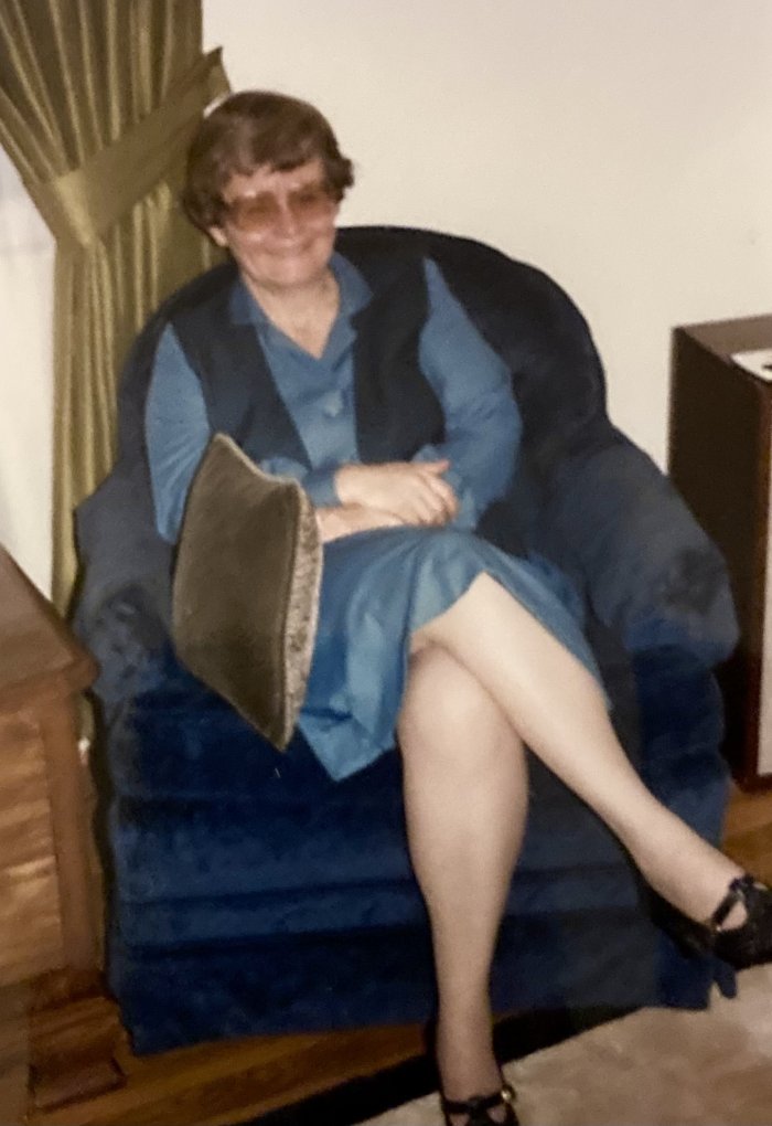 Eleanor Ford sits in a blue chair in a blue dress.